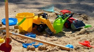 Lots of sand box toys in some sand